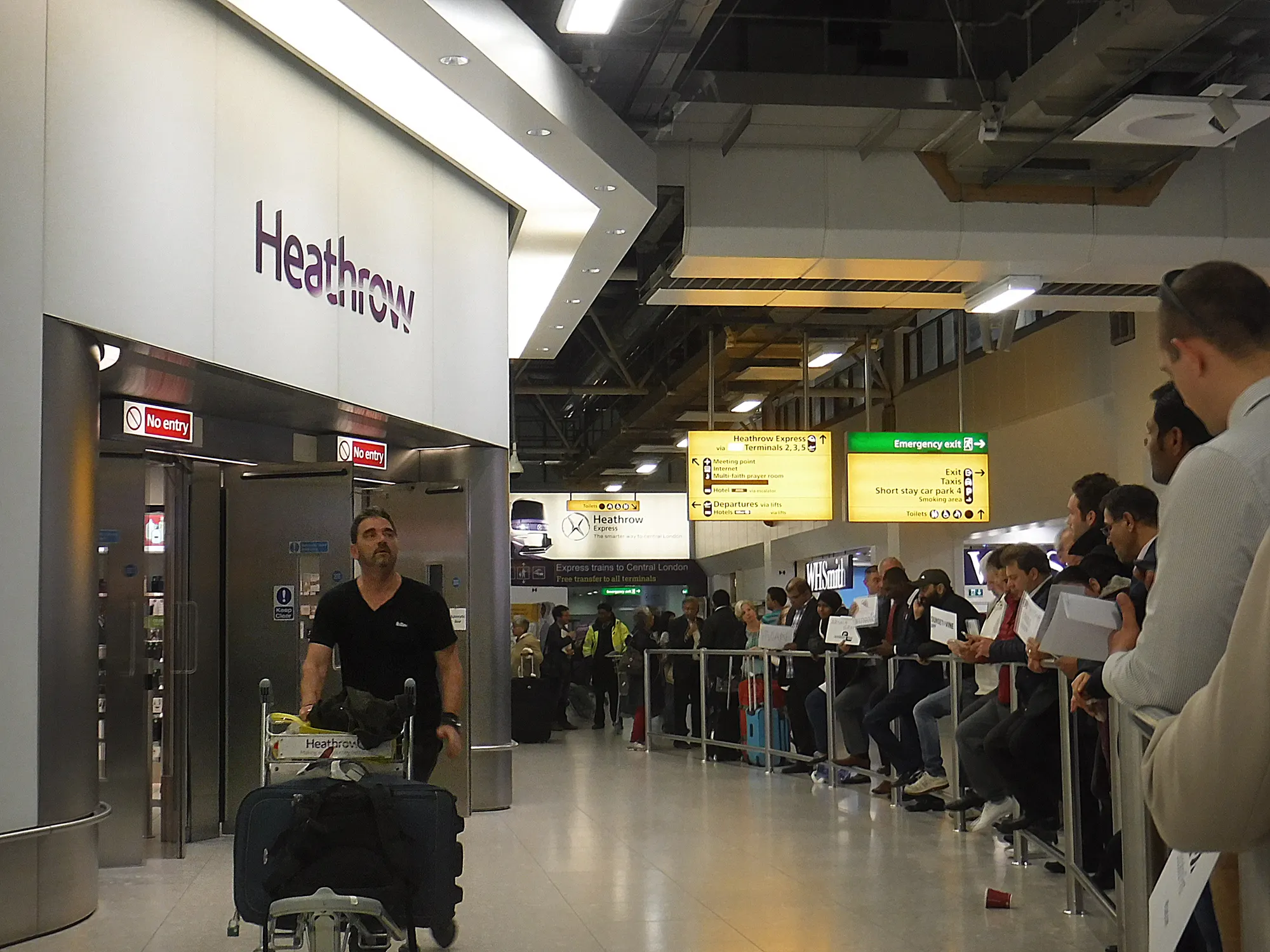 Public arrivals exit at Heathrow Terminal 4 photographed in June 2016; historic signage is not the current meeting instruction