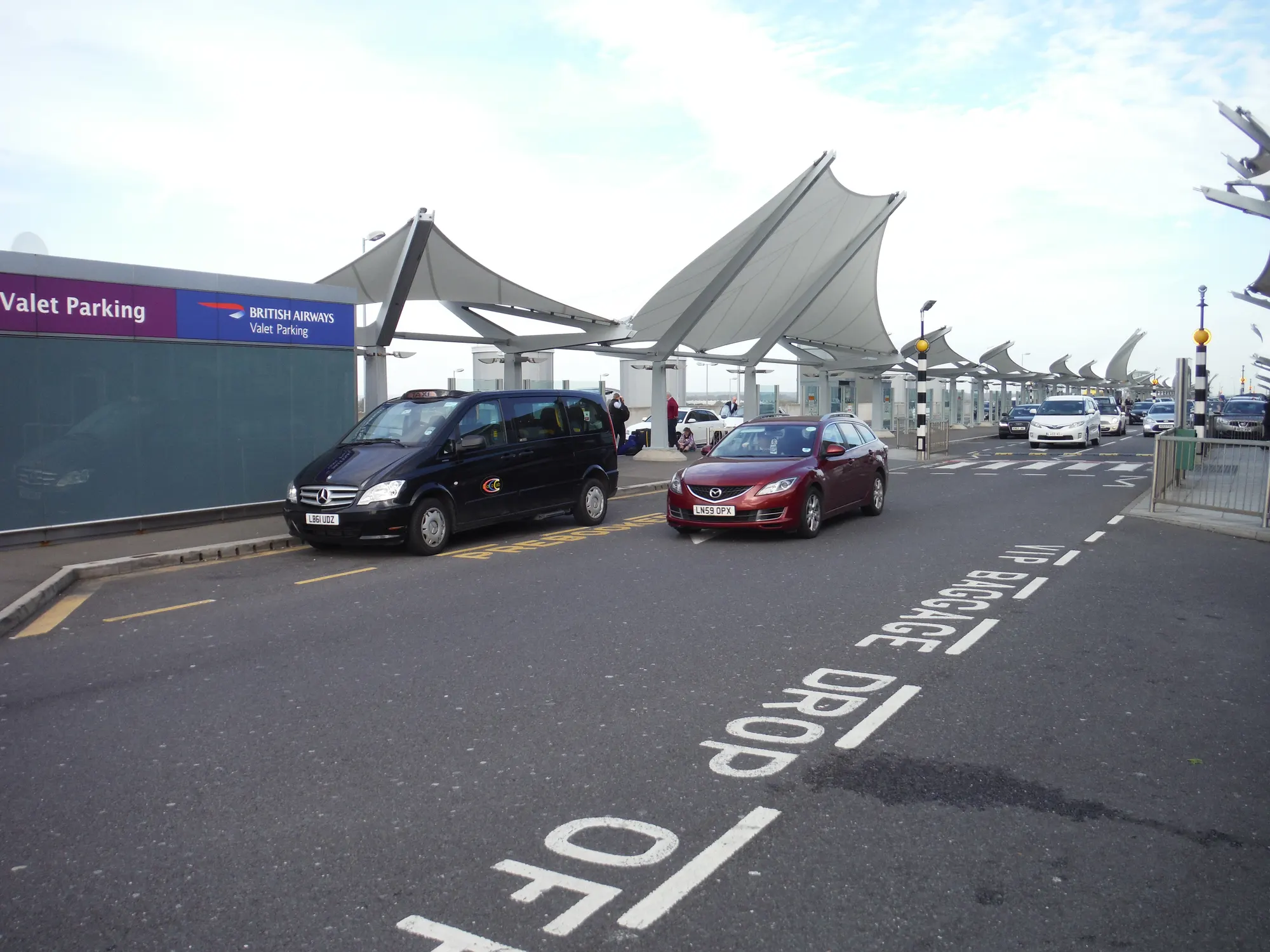 Heathrow Terminal 5 departures drop-off photographed in October 2014; historic lane and valet signs are not current guidance