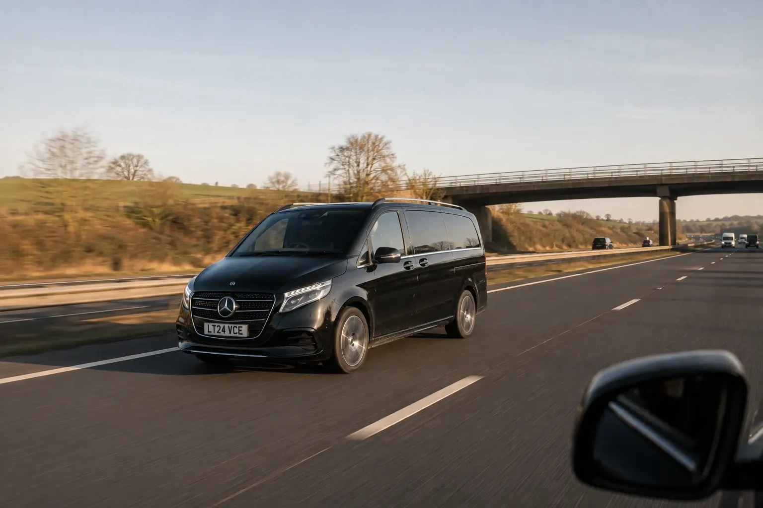 Black chauffeur people carrier travelling on an open motorway