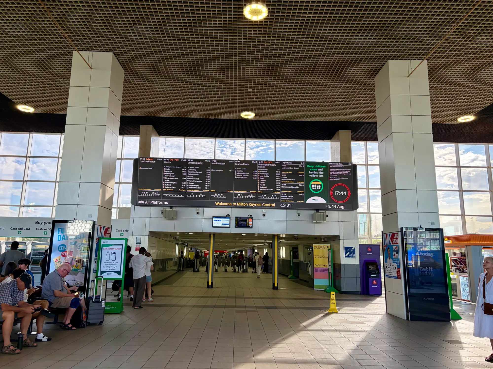 Public entrance hall and departure board inside Milton Keynes Central station in August 2026