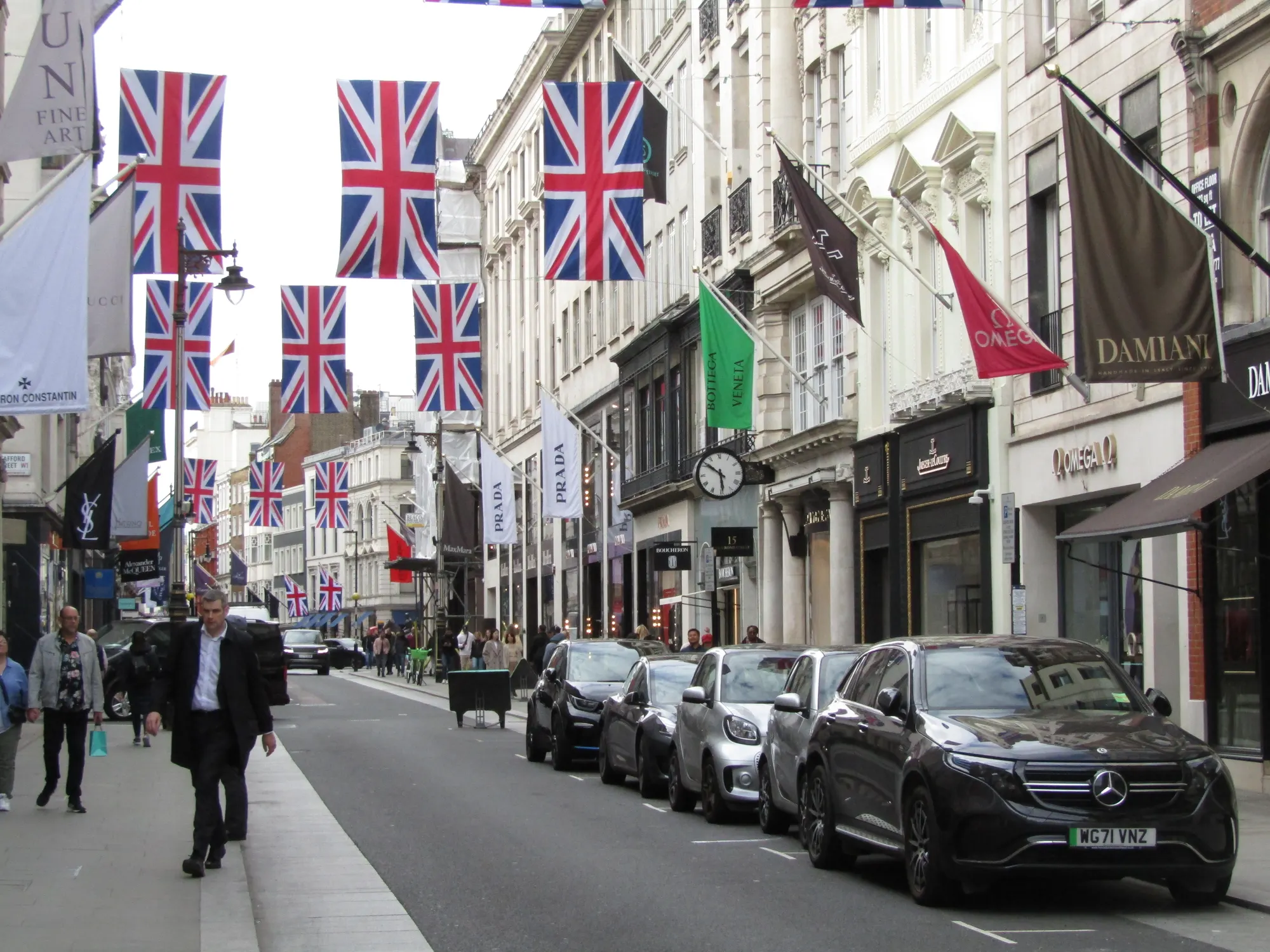 Old Bond Street in Mayfair with shops, pedestrians and flags