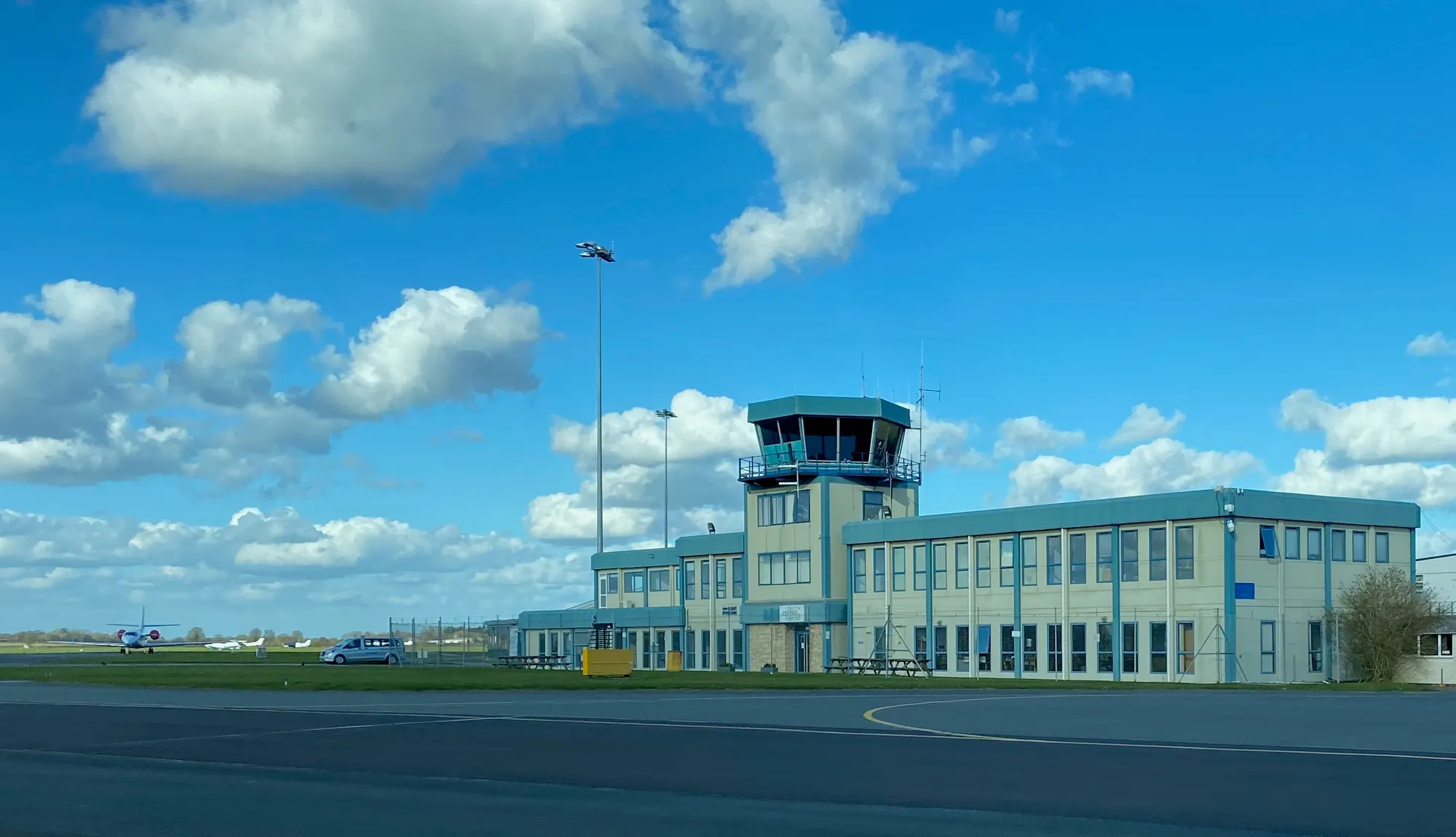 London Oxford Airport control tower and Cherwell Building beneath a bright spring sky