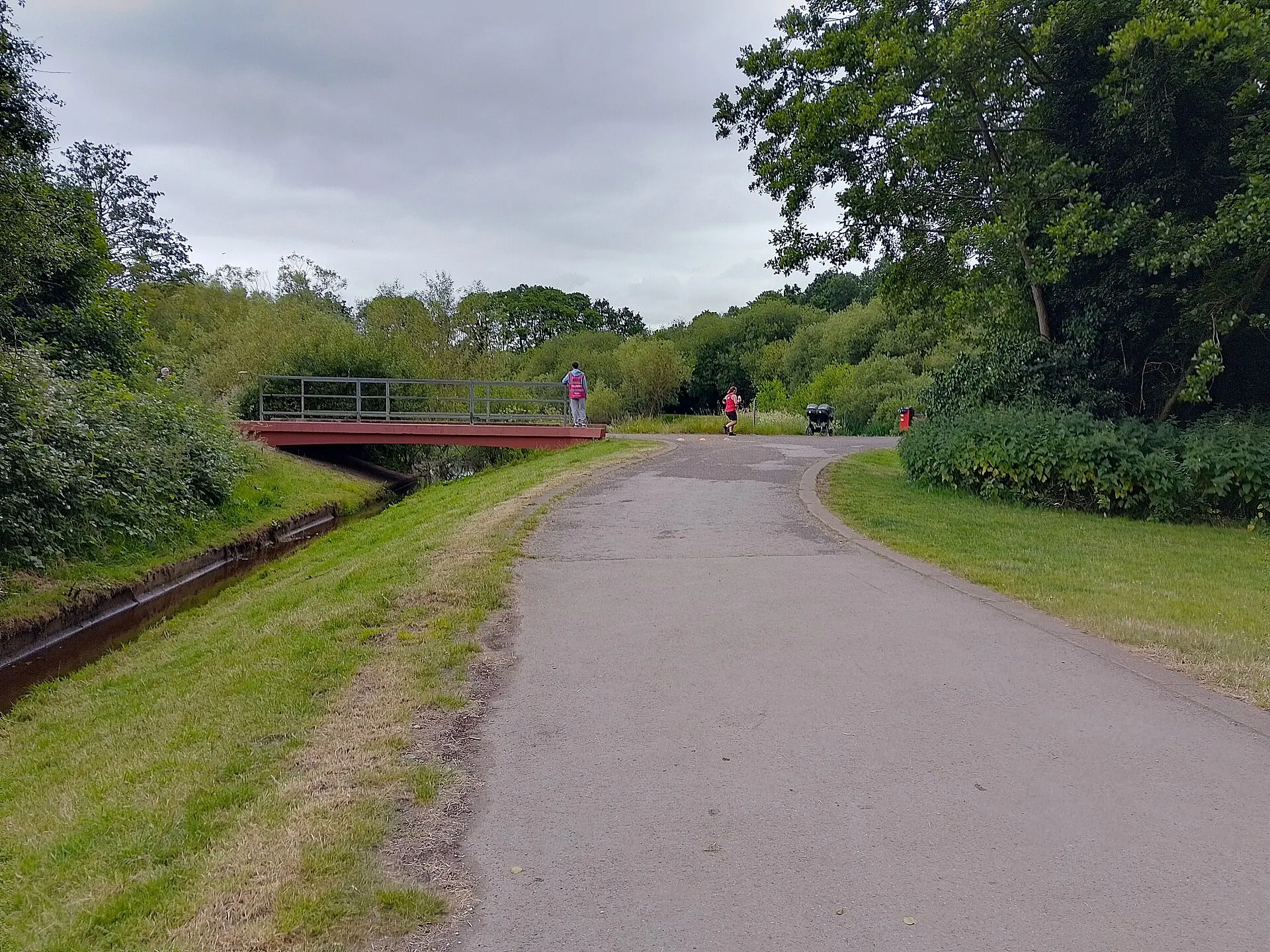 Tree-lined path and bridge at Sandhurst Memorial Park in June 2024