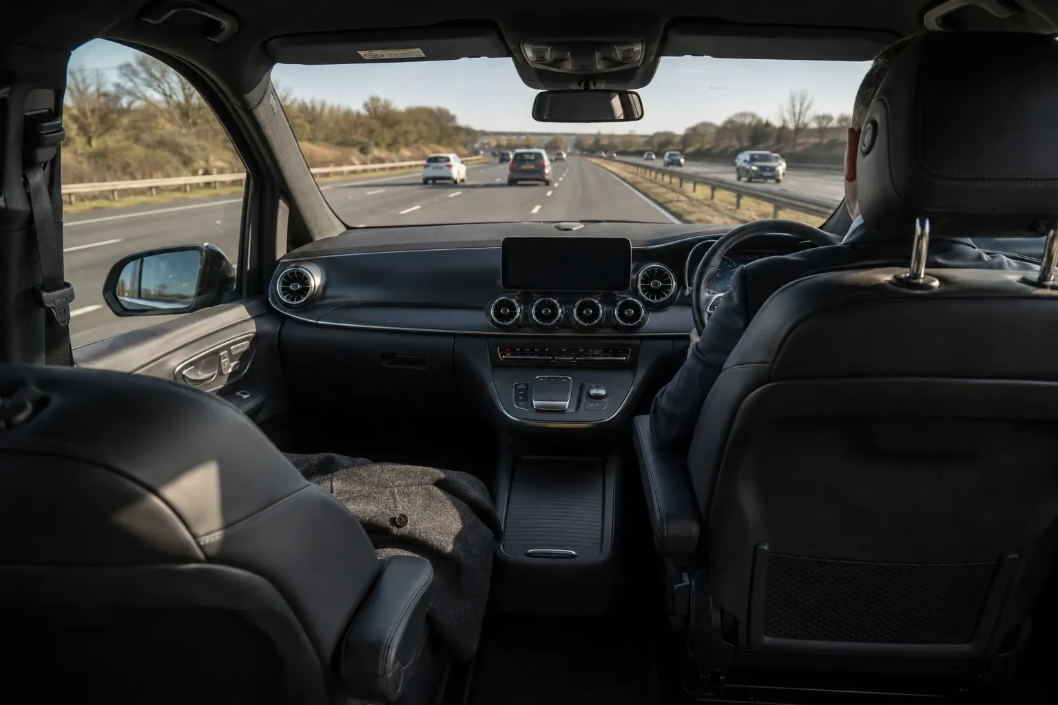 Open road viewed from a spacious chauffeur passenger cabin