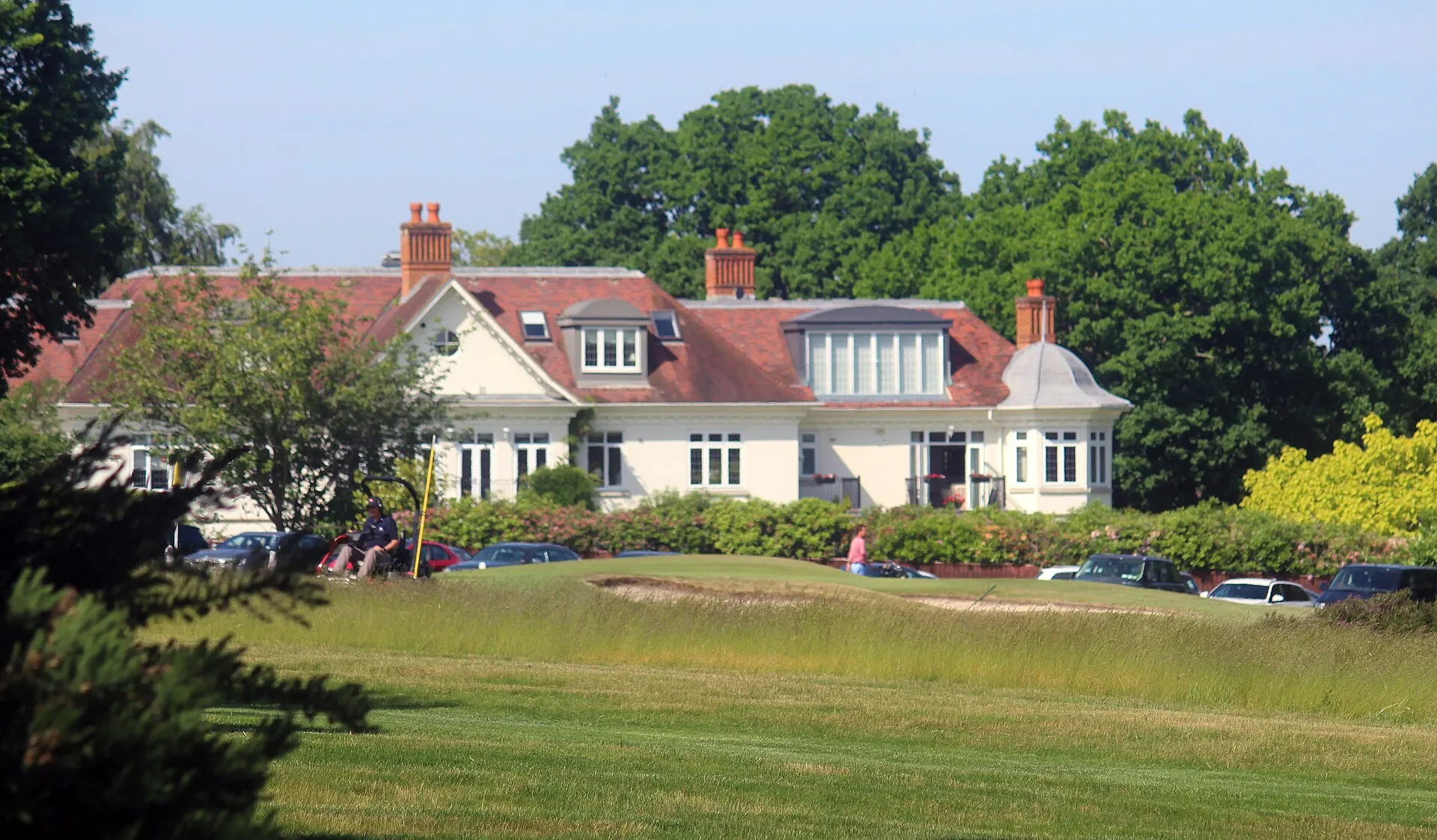 Sunningdale Golf Club clubhouse beyond a green, photographed in 2018