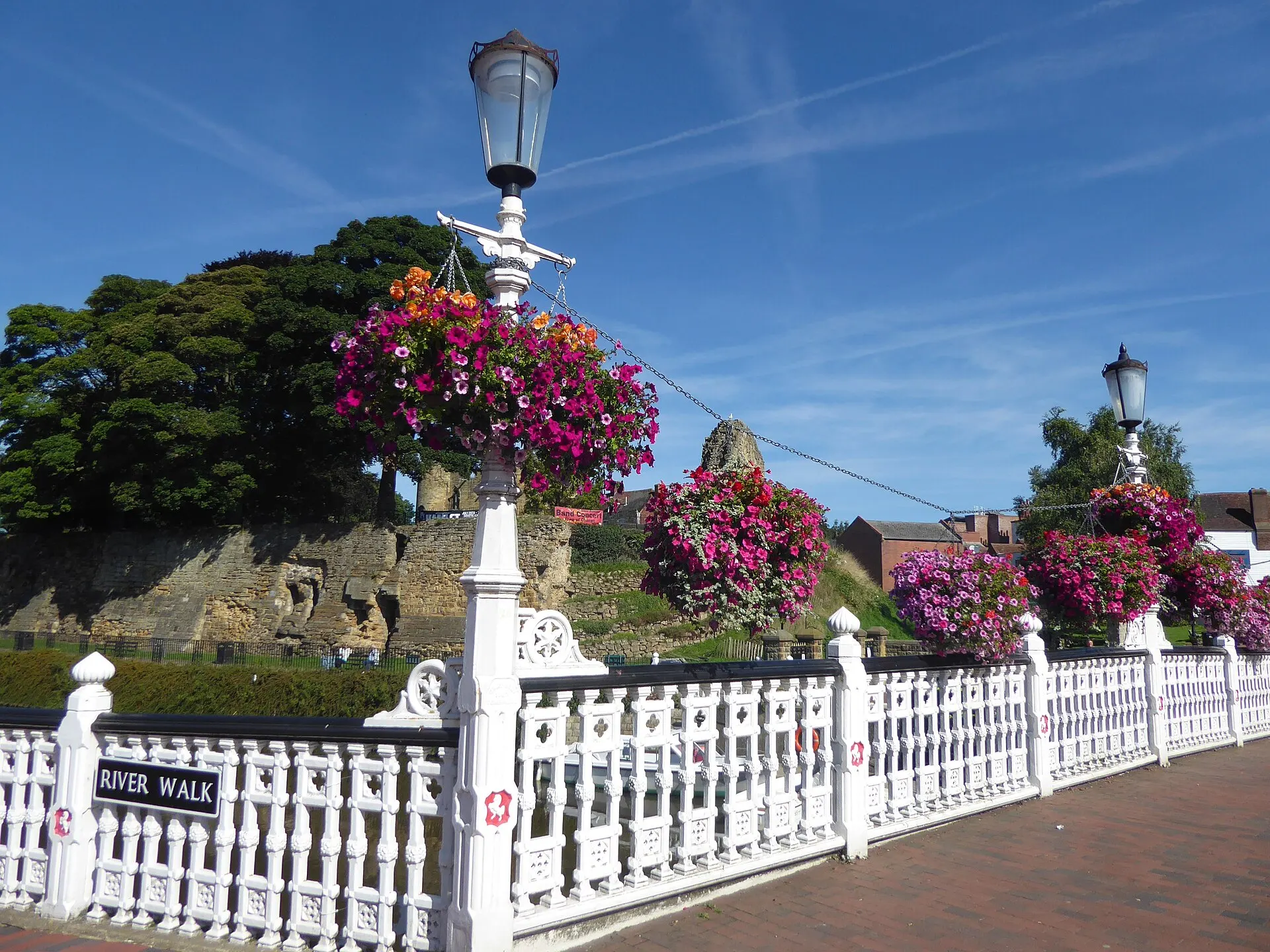 Flowers and castle wall beside Tonbridge High Street in August 2017